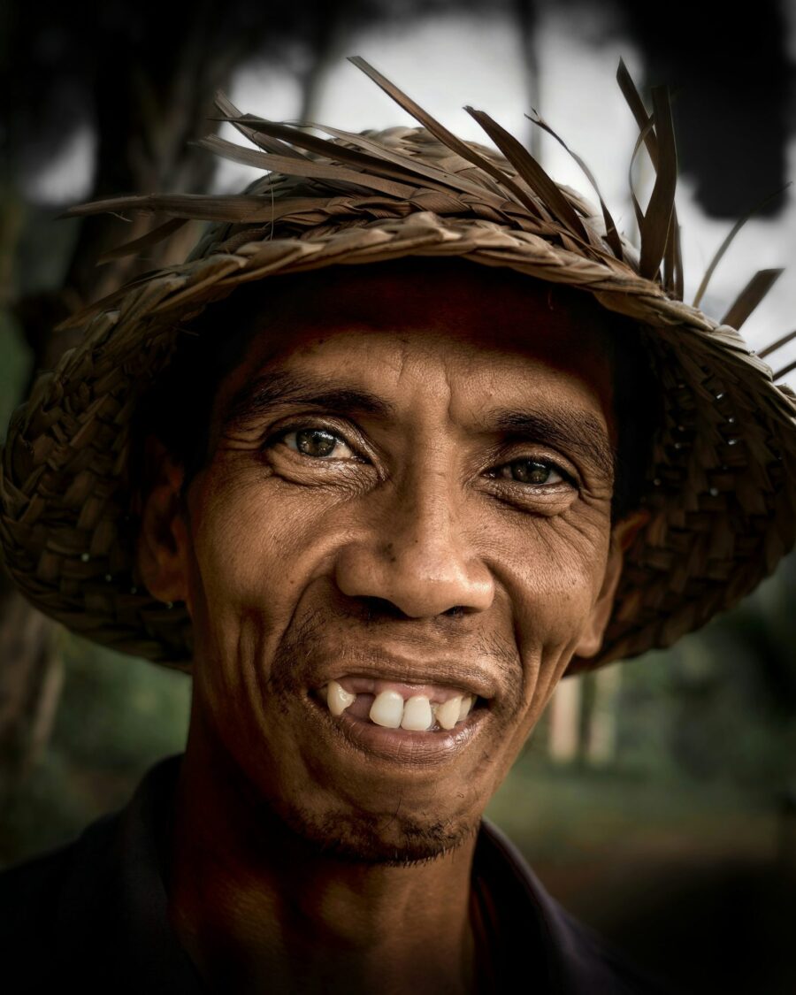 Smiling Indonesian farmer in a woven straw hat